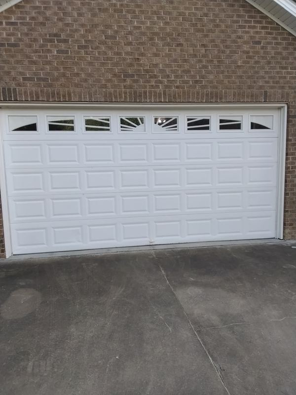 White garage door with windows on brick home