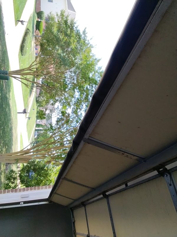 Close-up of a failed, flattened garage door bottom seal letting daylight and hot air under the door at a Norfolk Larchmont home, 2026