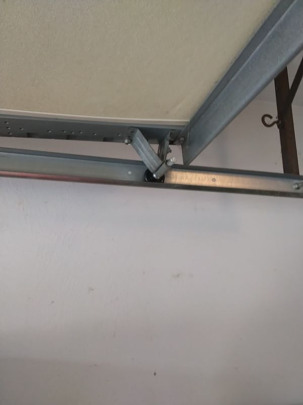 Garage door wheel off track job in Kempsville, Virginia Beach: the top roller and its bracket riding in the track on the same door